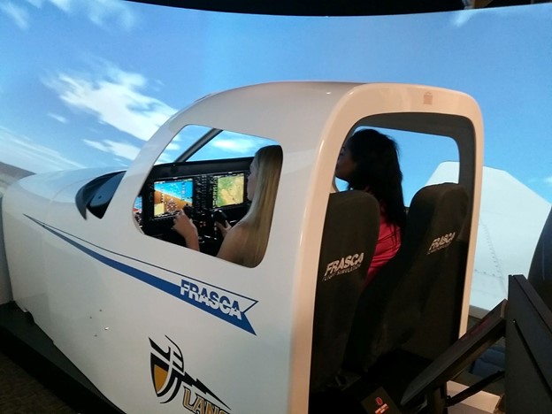 A CBU student and instructor in a flight simulator at Riverside Municipal Airport